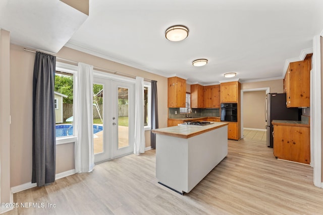 kitchen featuring french doors, light wood-style flooring, stainless steel appliances, and baseboards