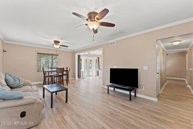 living area featuring visible vents, a ceiling fan, and crown molding