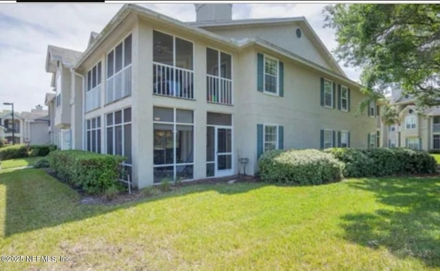 500 Sandiron Cir Unit 517, Ponte Vedra Beach, FL 32082 - back of house featuring a lawn, a chimney, stucco siding, and a sunroom