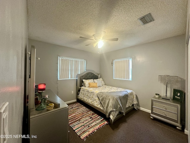 bedroom featuring ceiling fan, baseboards, visible vents, dark carpet, and a textured ceiling