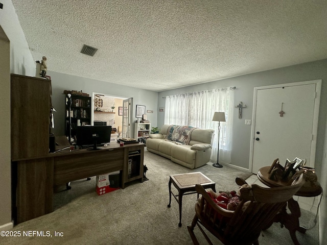 carpeted living area featuring visible vents and a textured ceiling