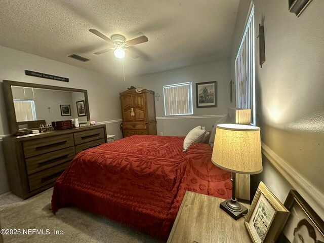 bedroom featuring visible vents, ceiling fan, and a textured ceiling