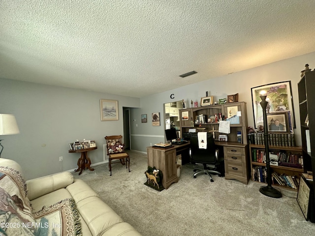 carpeted office featuring a textured ceiling and visible vents