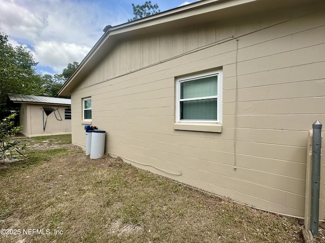 view of property exterior featuring an outdoor structure and concrete block siding