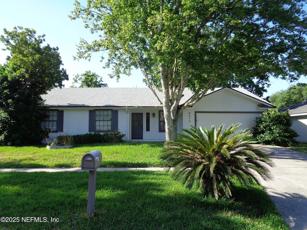 ranch-style home with a front yard, a garage, and concrete driveway