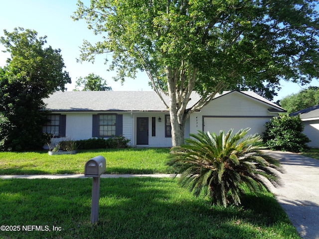 ranch-style home with a front yard, a garage, and concrete driveway