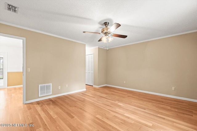 empty room featuring light wood-style floors, baseboards, a ceiling fan, and visible vents