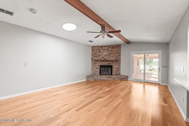 unfurnished living room featuring visible vents, a ceiling fan, light wood-style floors, and a brick fireplace