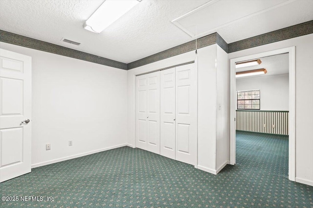 unfurnished bedroom featuring visible vents, carpet floors, baseboards, attic access, and a textured ceiling
