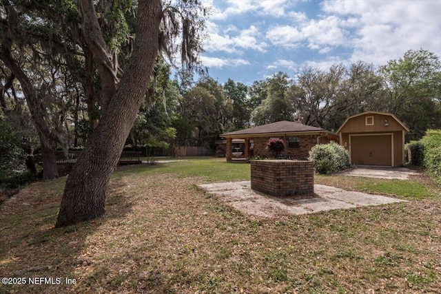 view of yard with an outdoor structure, a garage, and fence