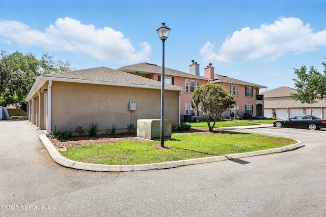 157 Jardin De Mer Pl Unit 157, Jacksonville Beach, FL 32250 - view of side of home with a lawn, a chimney, and stucco siding