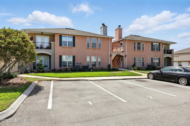 157 Jardin De Mer Pl Unit 157, Jacksonville Beach, FL 32250 - view of building exterior featuring central AC unit and uncovered parking