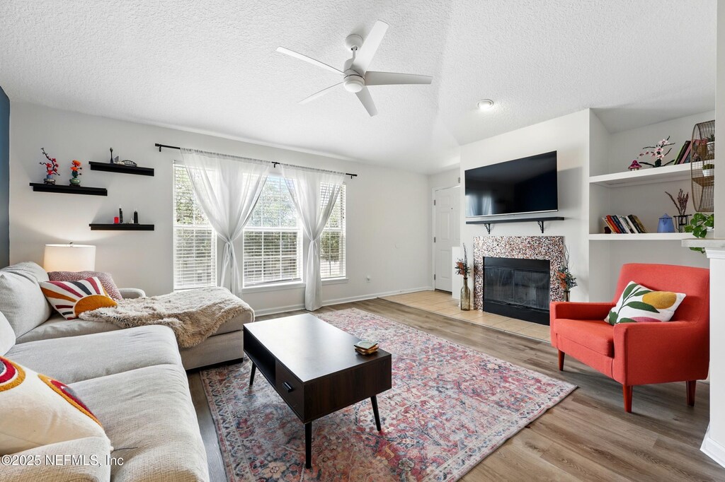 157 Jardin De Mer Pl Unit 157, Jacksonville Beach, FL 32250 - living room featuring wood finished floors, a textured ceiling, ceiling fan, and a fireplace