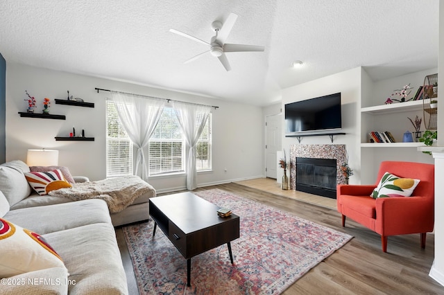 157 Jardin De Mer Pl Unit 157, Jacksonville Beach, FL 32250 - living room featuring wood finished floors, a textured ceiling, ceiling fan, and a fireplace