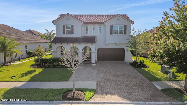 mediterranean / spanish home with a front lawn, a garage, decorative driveway, a tiled roof, and stucco siding