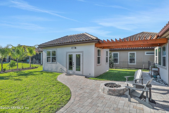 rear view of property featuring an outdoor fire pit, french doors, fence, and a tile roof