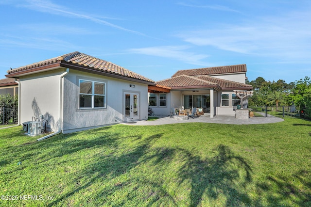 back of house featuring a patio, a tile roof, fence, a yard, and french doors