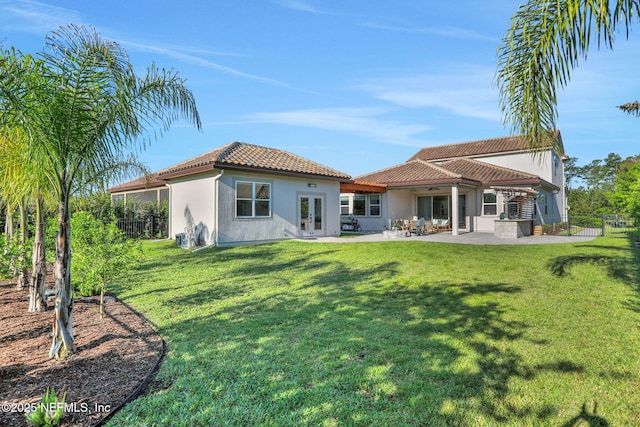 back of property featuring a tile roof, a patio, stucco siding, french doors, and fence