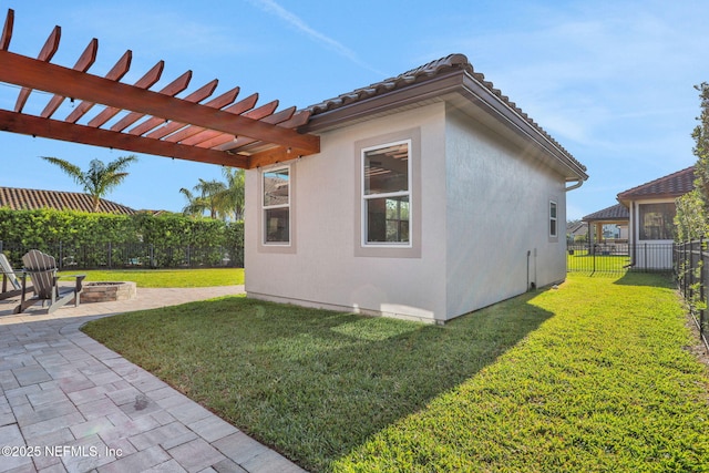 view of side of property with a patio, a pergola, an outdoor fire pit, a yard, and a fenced backyard