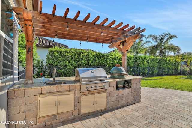view of patio / terrace featuring grilling area, a pergola, an outdoor kitchen, fence, and a sink