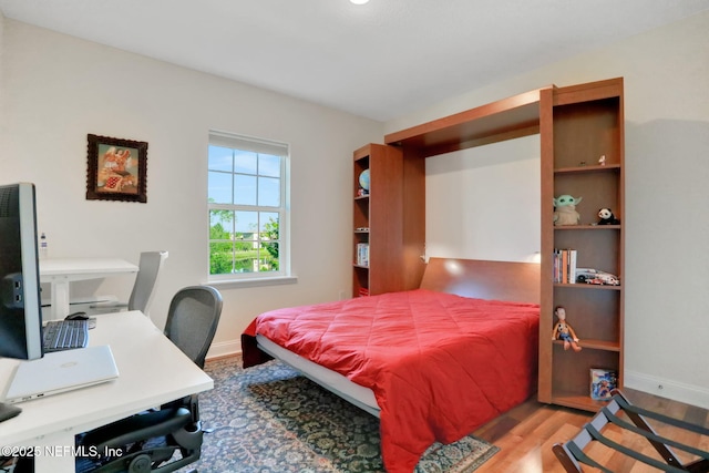 bedroom featuring baseboards and wood finished floors