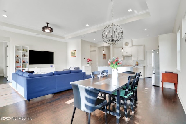 dining space featuring a raised ceiling and dark wood-type flooring