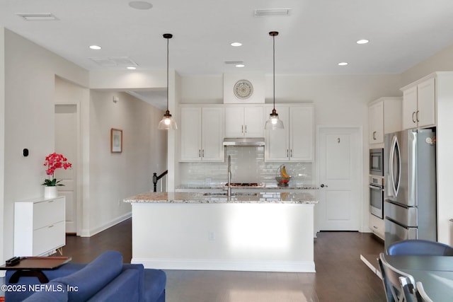 kitchen with white cabinets, backsplash, stainless steel appliances, and under cabinet range hood