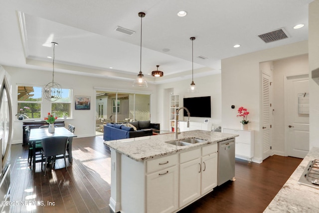 kitchen with appliances with stainless steel finishes, a raised ceiling, visible vents, and a sink