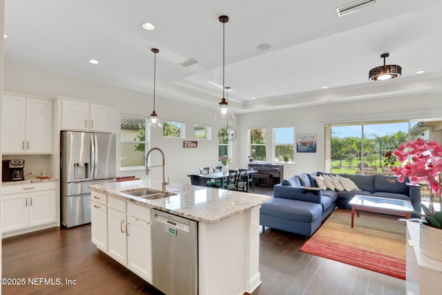 kitchen with appliances with stainless steel finishes, a sink, dark wood-style floors, visible vents, and open floor plan