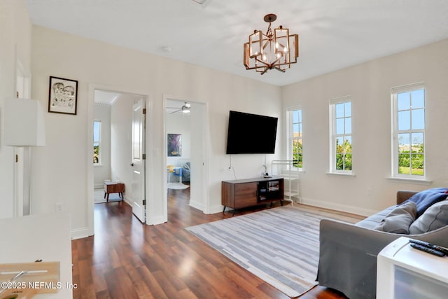 living room with a chandelier, wood finished floors, and baseboards