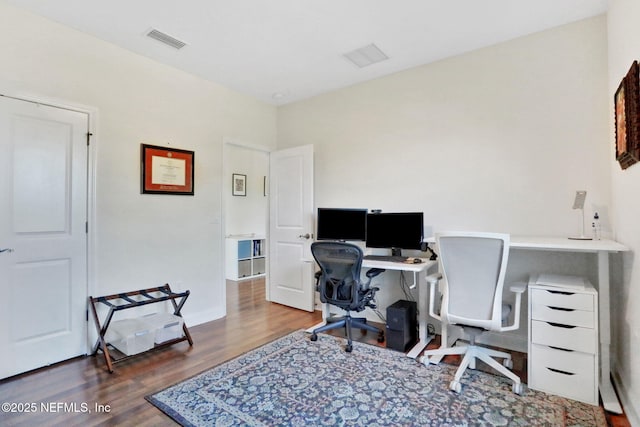 office area with baseboards, visible vents, and wood finished floors