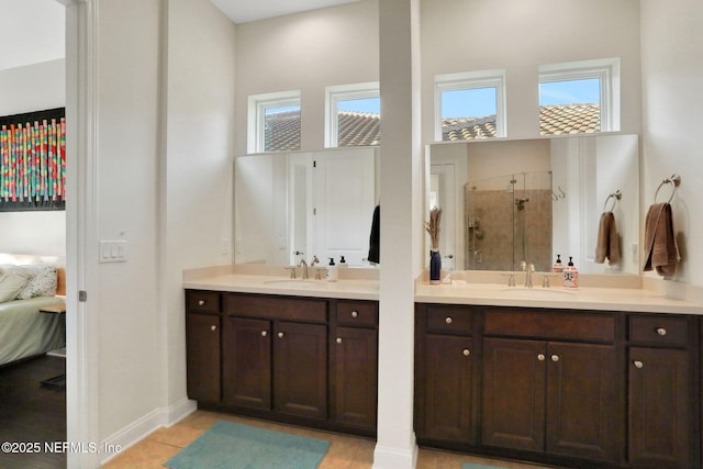 ensuite bathroom featuring a tile shower, ensuite bathroom, vanity, and baseboards