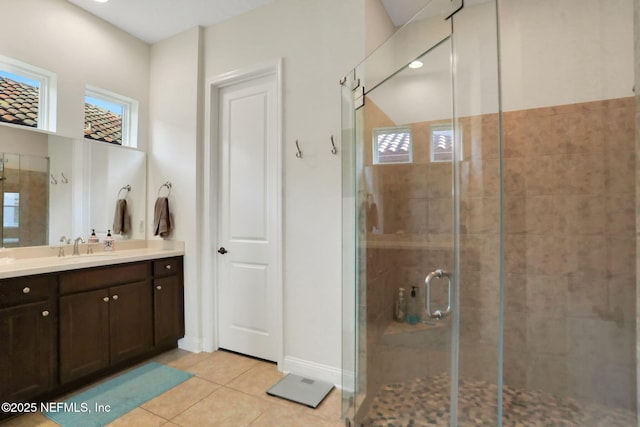 full bath with baseboards, a shower stall, tile patterned flooring, and vanity