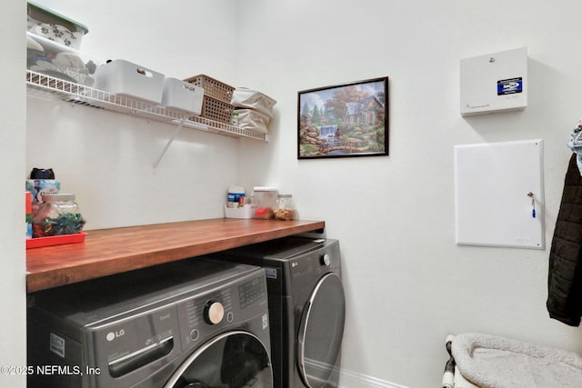 washroom with independent washer and dryer, laundry area, and baseboards