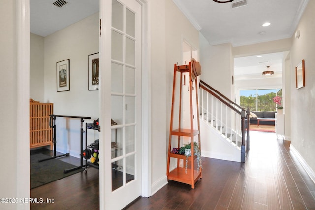 hallway featuring stairway, wood finished floors, visible vents, and baseboards