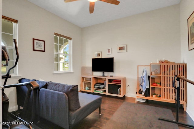 living area with baseboards, wood finished floors, and ceiling fan
