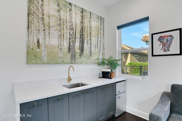 bar featuring baseboards and a sink