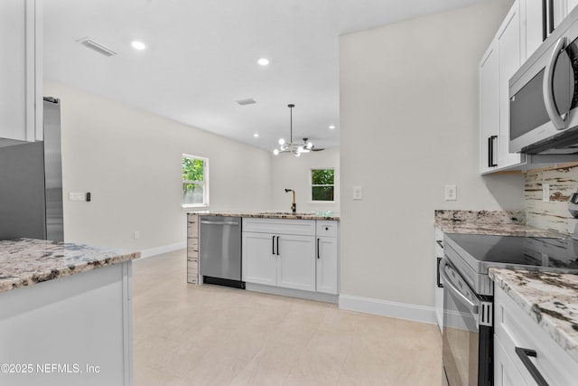 7708 Galveston Ave, Jacksonville, FL 32211 - kitchen with appliances with stainless steel finishes, visible vents, white cabinetry, and a sink