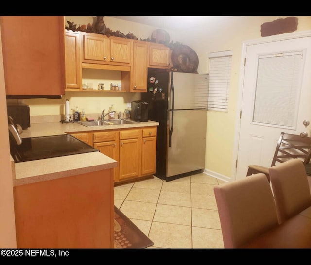 kitchen featuring freestanding refrigerator, light tile patterned floors, open shelves, light countertops, and a sink