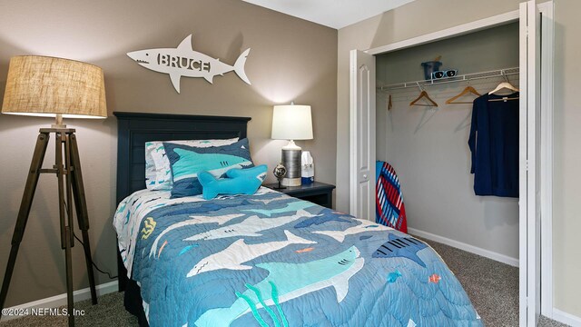carpeted bedroom with a closet and baseboards