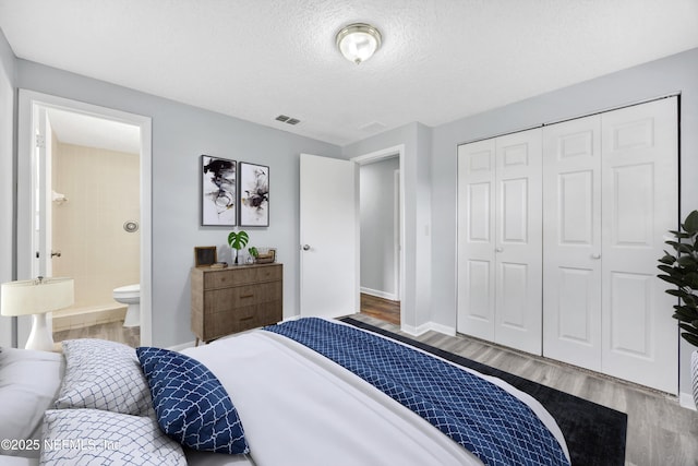 4043 Marland St, Jacksonville, FL 32209 - bedroom with a textured ceiling, visible vents, a closet, baseboards, and wood finished floors