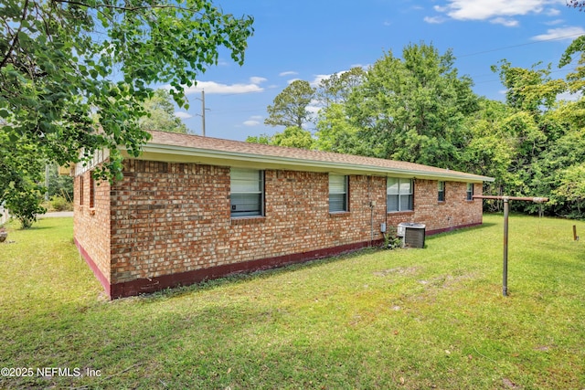 4043 Marland St, Jacksonville, FL 32209 - back of house with central air condition unit, a yard, and brick siding