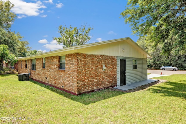 4043 Marland St, Jacksonville, FL 32209 - rear view of house featuring brick siding, cooling unit, and a yard