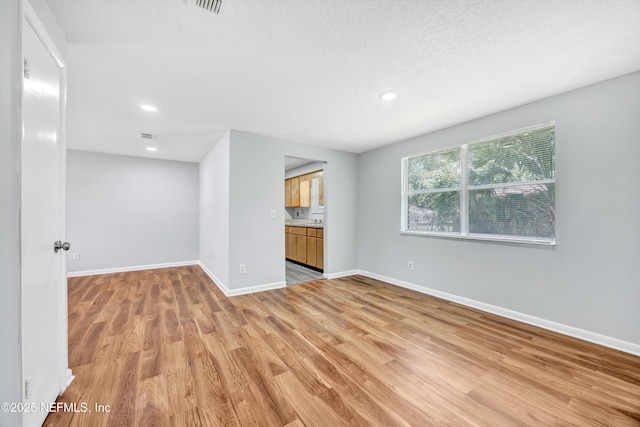 4043 Marland St, Jacksonville, FL 32209 - unfurnished living room featuring light wood-style flooring, a sink, visible vents, baseboards, and recessed lighting