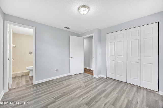 4043 Marland St, Jacksonville, FL 32209 - unfurnished bedroom with wood finished floors, a closet, baseboards, visible vents, and a textured ceiling