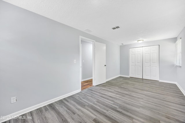 4043 Marland St, Jacksonville, FL 32209 - unfurnished bedroom featuring wood finished floors, visible vents, a textured ceiling, and baseboards