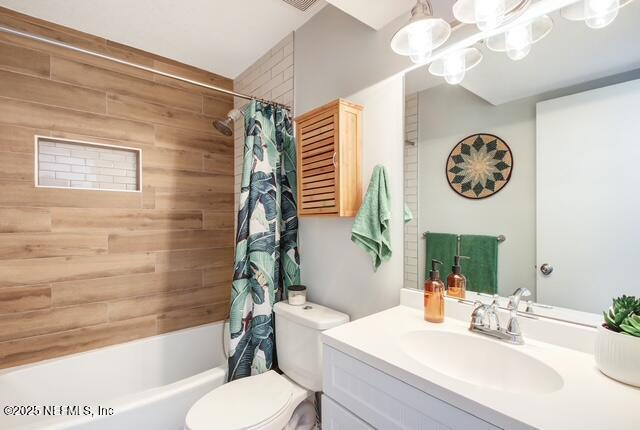 full bathroom featuring vanity, shower / tub combo, toilet, and a chandelier