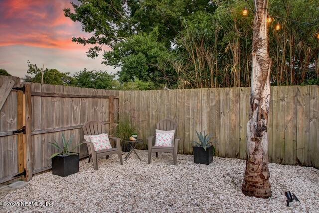 patio terrace at dusk with a fenced backyard