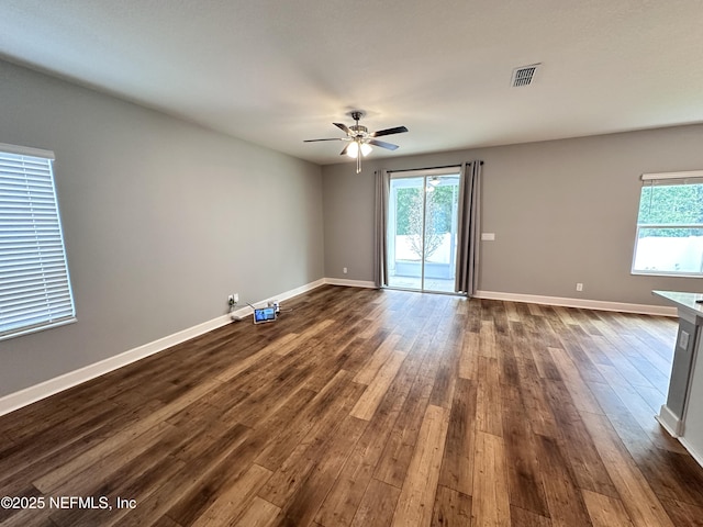 1116 Morgans Treasure Rd, Saint Augustine, FL 32084 - empty room with visible vents, dark wood-style flooring, ceiling fan, and a healthy amount of sunlight