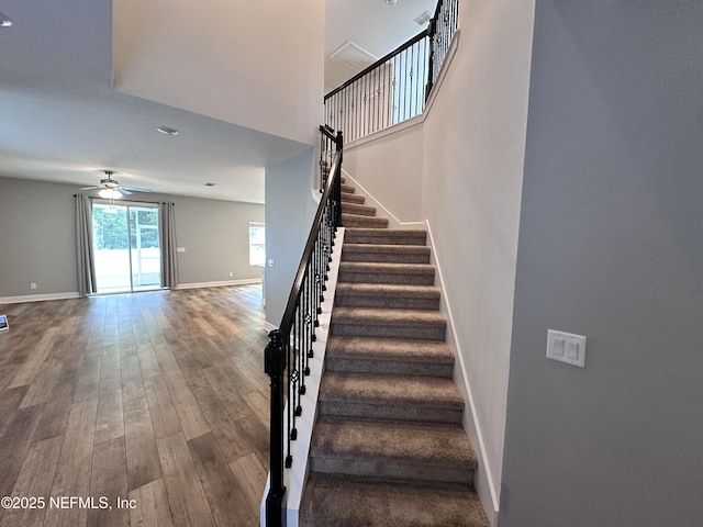 1116 Morgans Treasure Rd, Saint Augustine, FL 32084 - staircase with baseboards, a ceiling fan, a towering ceiling, and wood finished floors